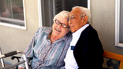 Lovely elderly couple sitting outside on porch together