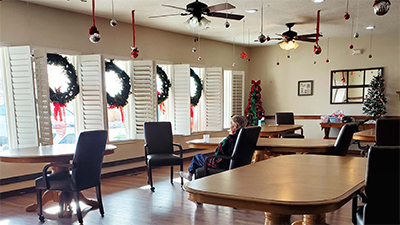 The memory care community dining room is well-lit and spacious