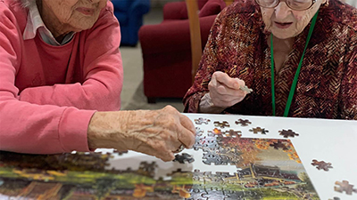 Two respite care residents piecing together a puzzle