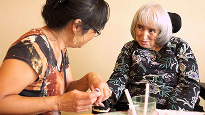 Elderly woman getting her nails painted