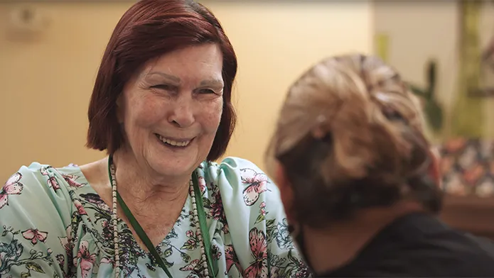 Elderly woman smiling with caregiver