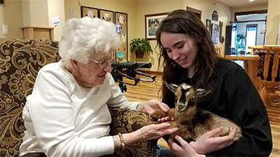 Elderly resident enjoys visit from petting zoo