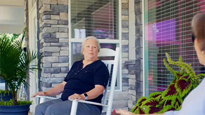 Senior woman sitting in a rocking chair outside