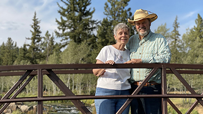 Senior couple standing happily on an outdoor bridge