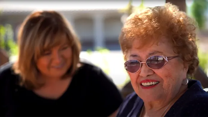 Two women enjoying each others company outside in the sun.