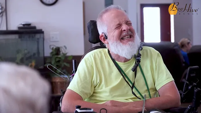 Resident laughs with others in the BeeHive