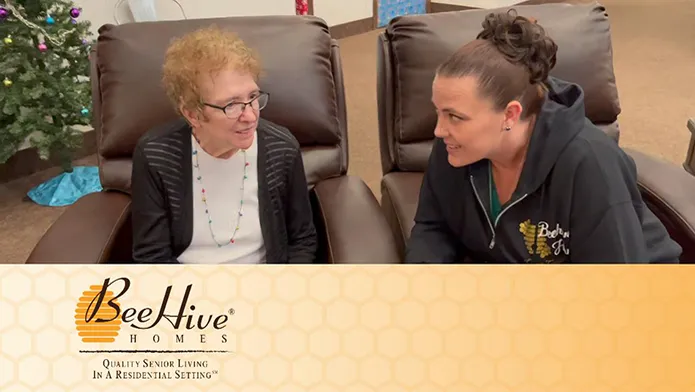 Elderly woman sitting with caregiver