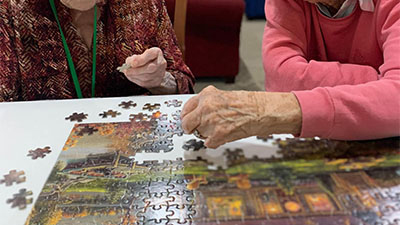 Memory care residents build a puzzle