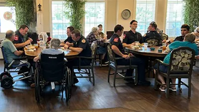 Residents and guests gathered around tables at BeeHive Homes of Abilene